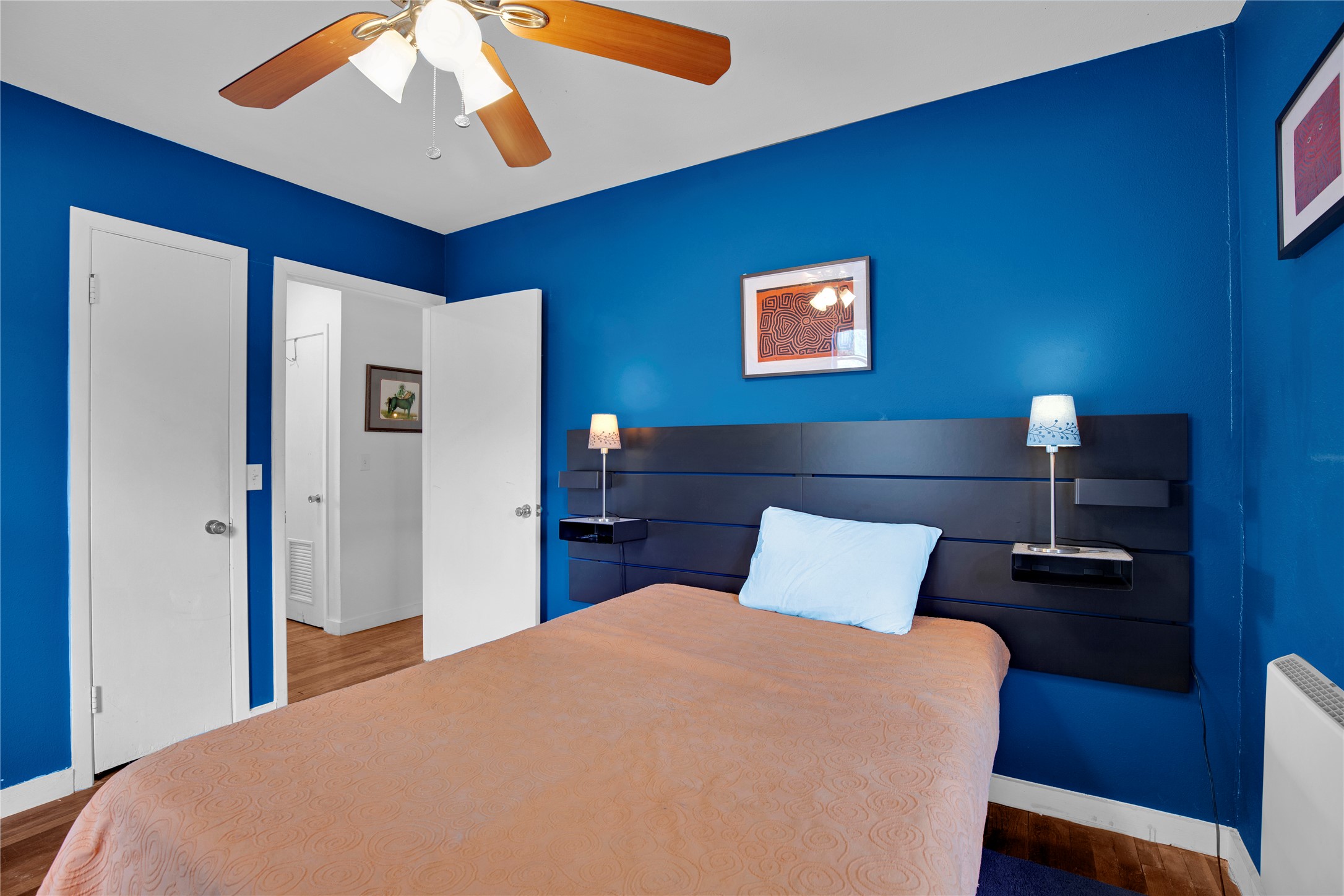 1607 East 4th Street Taylor, TX 76574 - Photo 20 of 32 Bedroom featuring dark wood-style flooring, a ceiling fan, and radiator heating unit