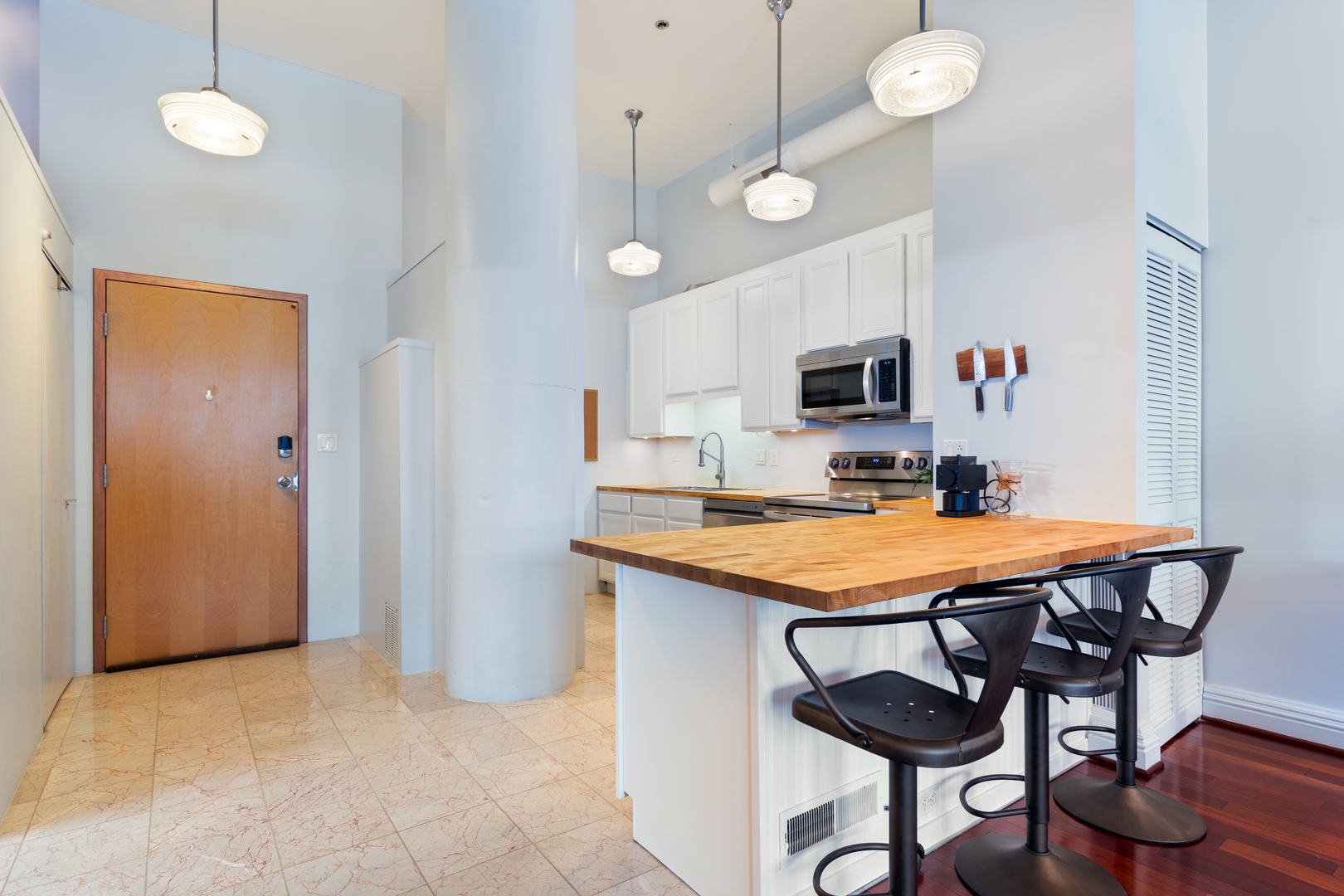 801 South Wells Street, Unit 1006 Chicago, IL 60607 - Photo 2 of 25 a room with stainless steel appliances a table and chairs in it