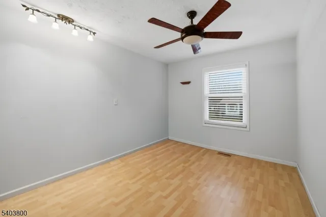 an empty room with a window and a fan