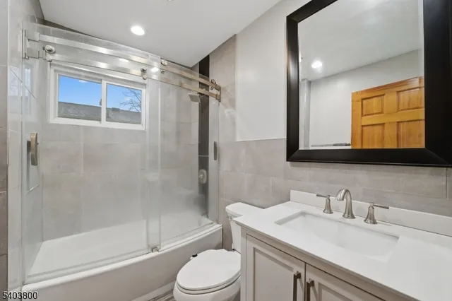 a bathroom with a sink toilet vanity and shower