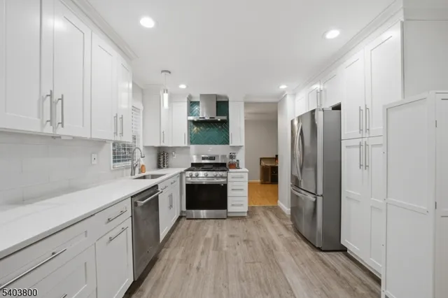 a kitchen with a refrigerator a sink and a stove top oven