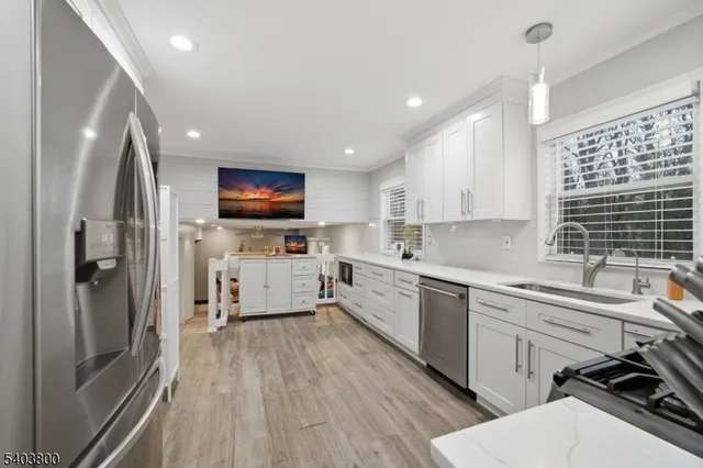 a kitchen with a sink stainless steel appliances and window