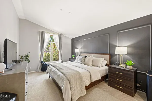 a bedroom with a bed potted plant and a large window