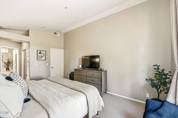 a bedroom with a bed and a potted plant