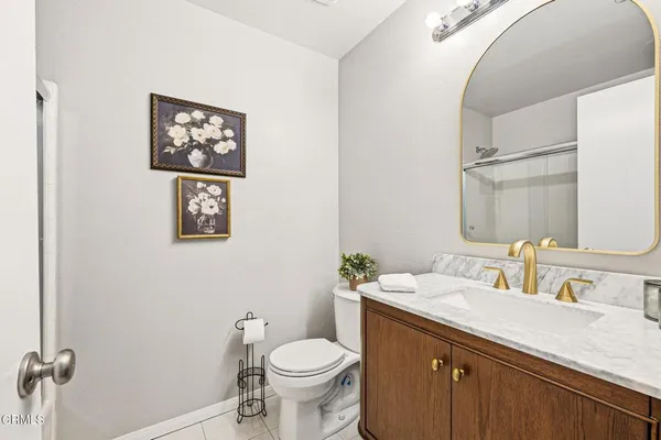 a bathroom with a granite countertop sink mirror and toilet