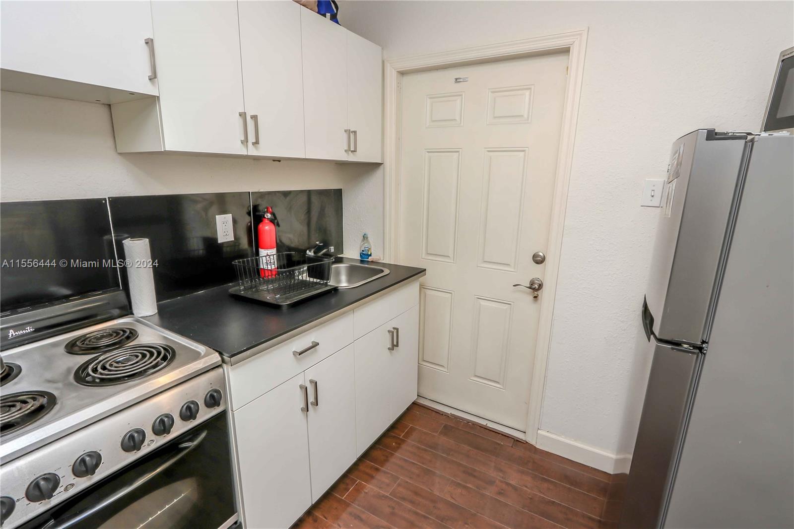 5635 Southwest 5th Terrace Miami, FL 33134 - Photo 25 of 28 a kitchen with stainless steel appliances a stove a refrigerator and cabinets