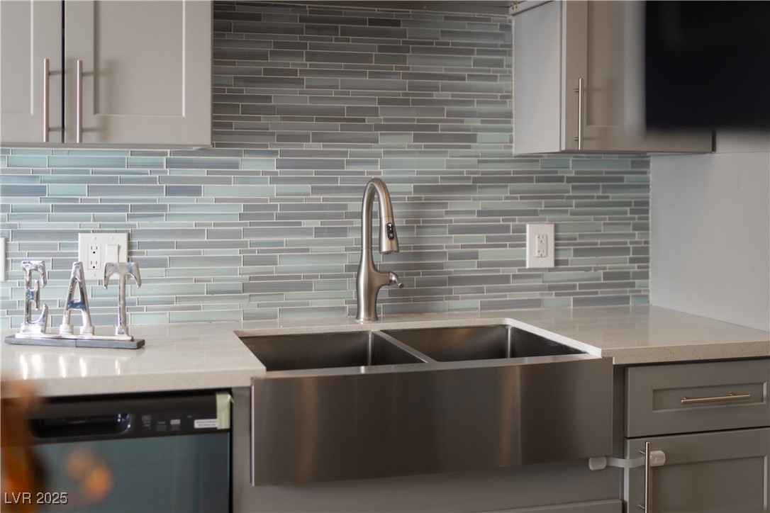 3318 North Decatur Boulevard, Unit 2143 Las Vegas, NV 89130 - Photo 1 of 34 Kitchen with light stone counters, decorative backsplash, dishwasher, and gray cabinets