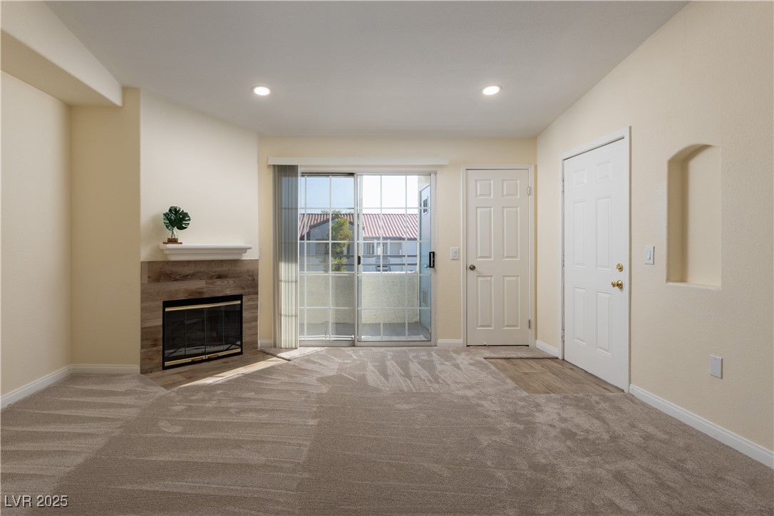 3318 North Decatur Boulevard, Unit 2143 Las Vegas, NV 89130 - Photo 12 of 34 Unfurnished living room featuring a tile fireplace, carpet, and recessed lighting