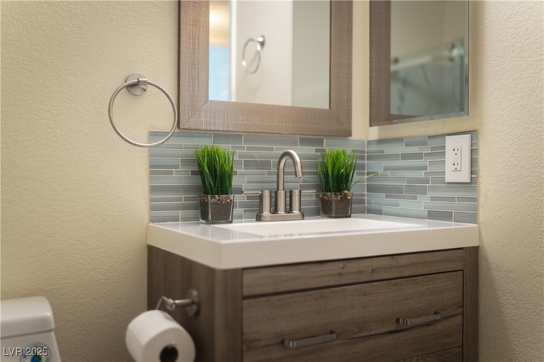 3318 North Decatur Boulevard, Unit 2143 Las Vegas, NV 89130 - Photo 16 of 34 Bathroom featuring a textured wall, vanity, and tasteful backsplash