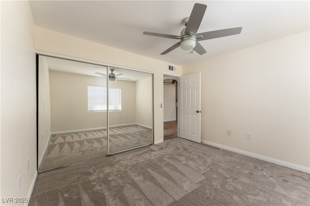 3318 North Decatur Boulevard, Unit 2143 Las Vegas, NV 89130 - Photo 21 of 34 Unfurnished bedroom featuring carpet floors, a closet, and ceiling fan