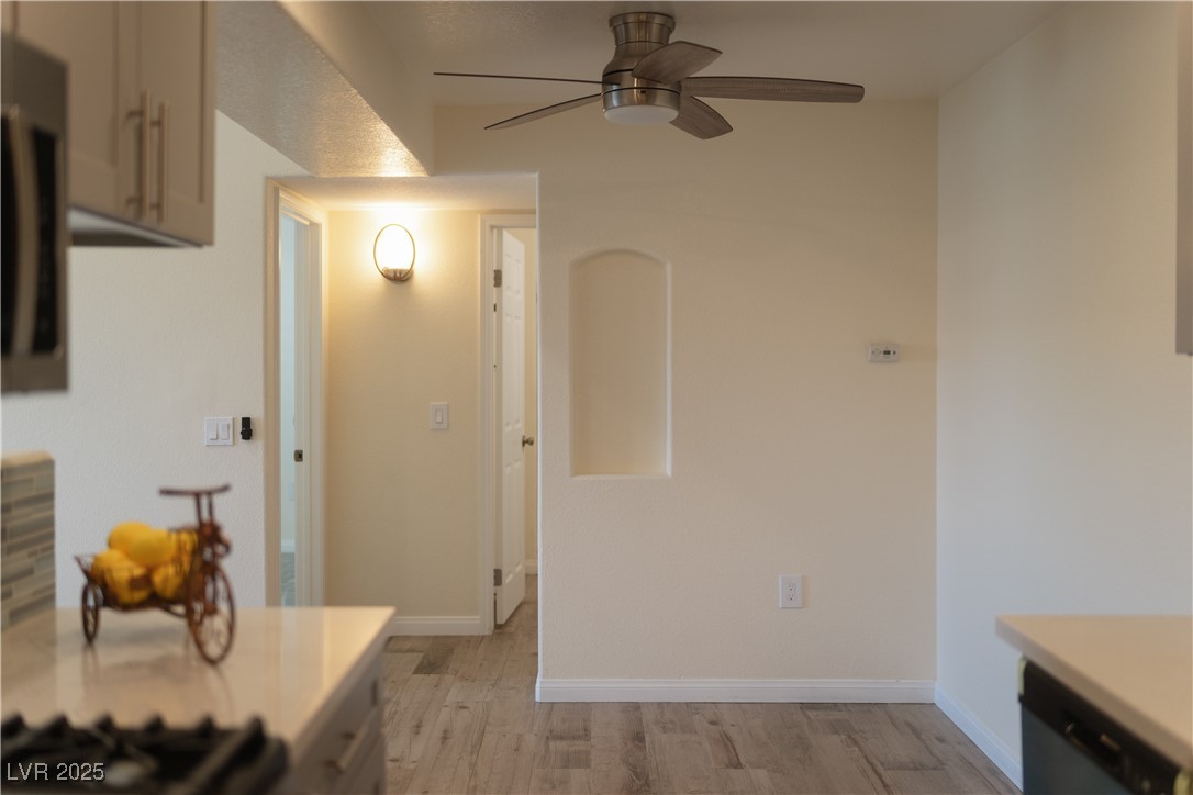 3318 North Decatur Boulevard, Unit 2143 Las Vegas, NV 89130 - Photo 9 of 34 Kitchen featuring light wood-style flooring, light countertops, ceiling fan, dishwasher, and gas stovetop