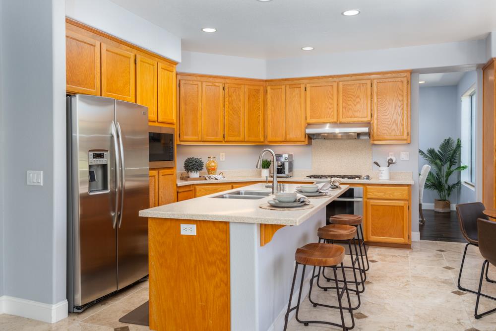 30152 Bridgeview Way Hayward, CA 94544 - Photo 13 of 37 a kitchen with stainless steel appliances granite countertop a refrigerator a sink a stove and island with wooden floor
