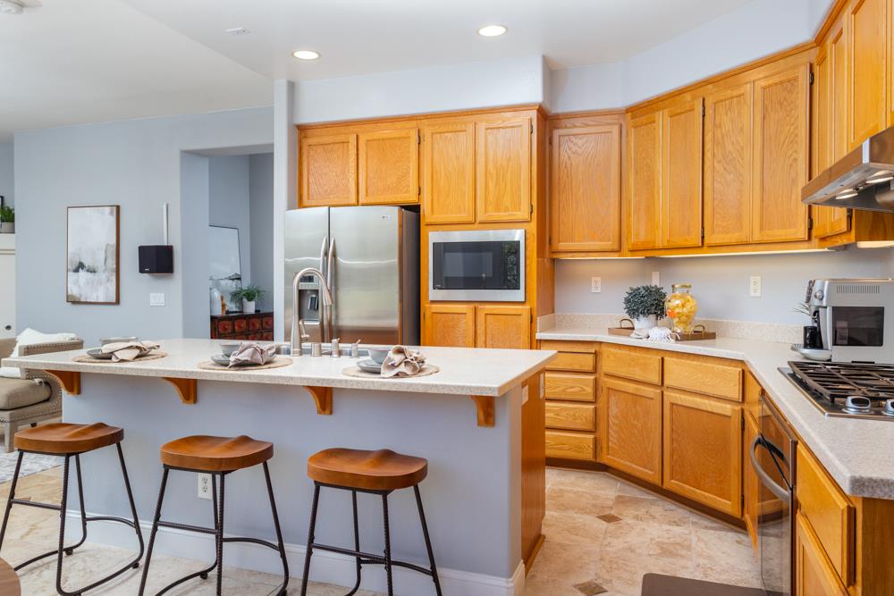 30152 Bridgeview Way Hayward, CA 94544 - Photo 15 of 37 a kitchen with stainless steel appliances granite countertop a stove a sink dishwasher and white cabinets with wooden floor