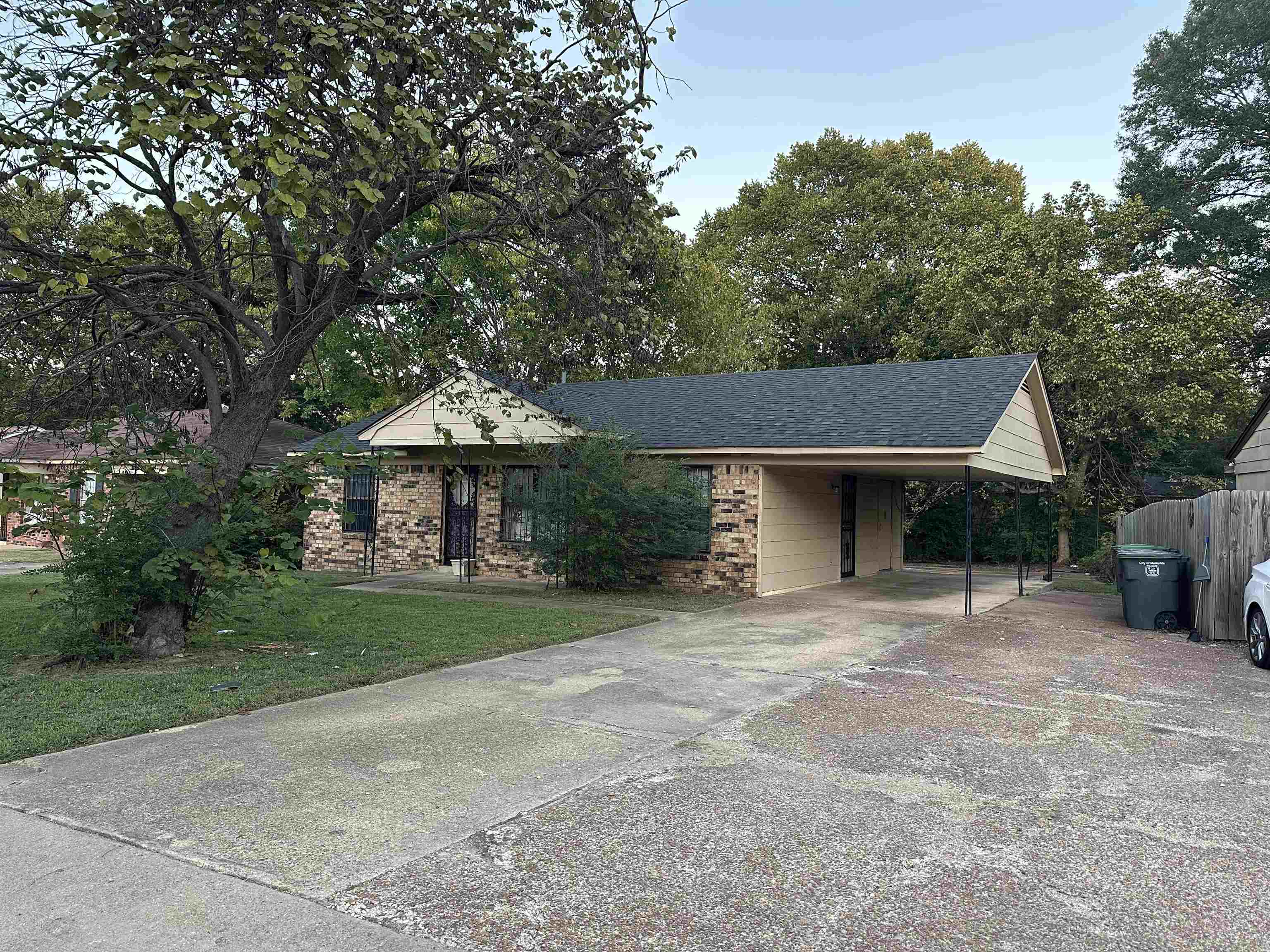 4850 Applestone Street Memphis, TN 38109 - Photo 2 of 9 a front view of a house with a garden and trees