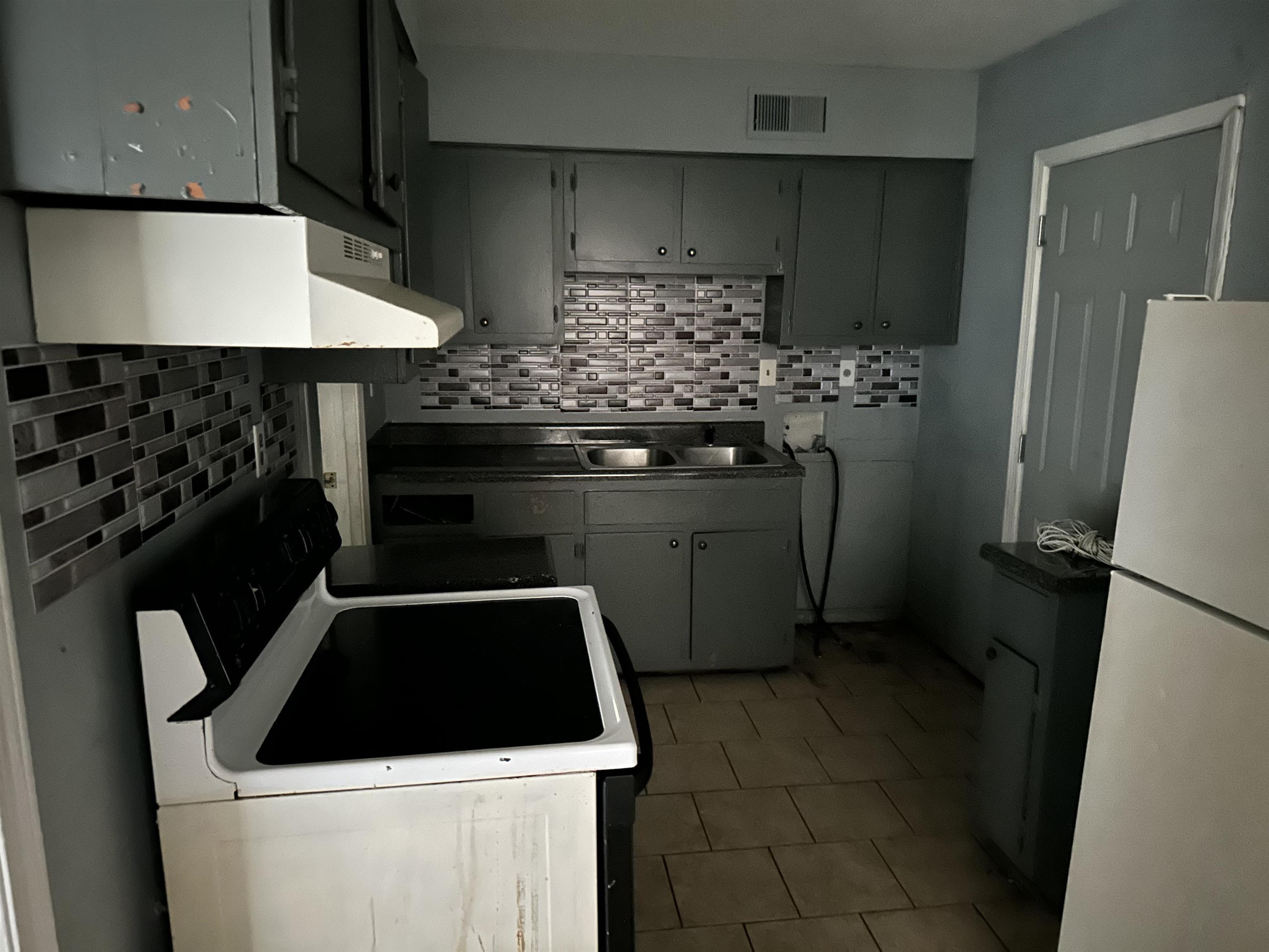 4850 Applestone Street Memphis, TN 38109 - Photo 6 of 9 a kitchen with a sink a stove and refrigerator
