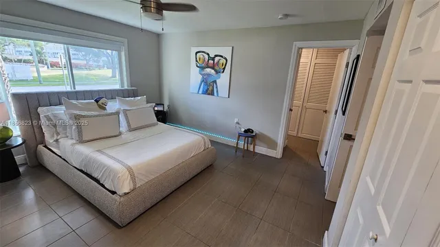 a bedroom with a bed lamp and a large window