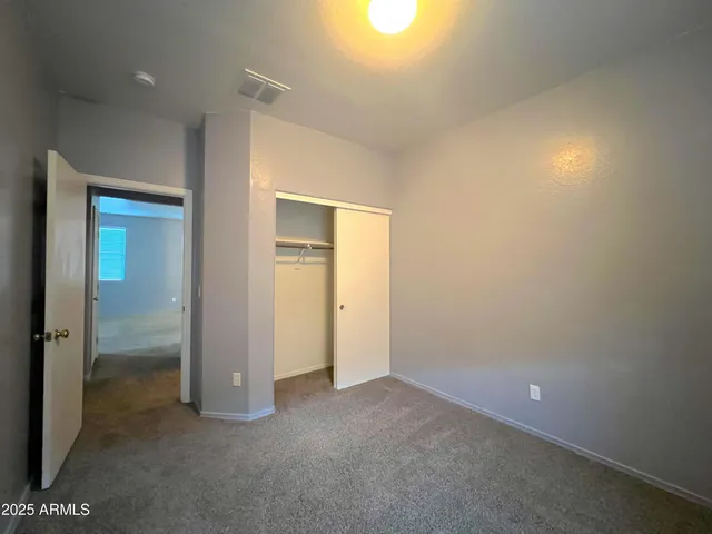 an empty room with closet and a bathroom view