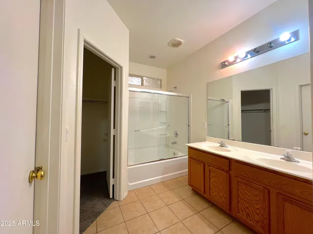 a spacious bathroom with a shower a sink and a mirror