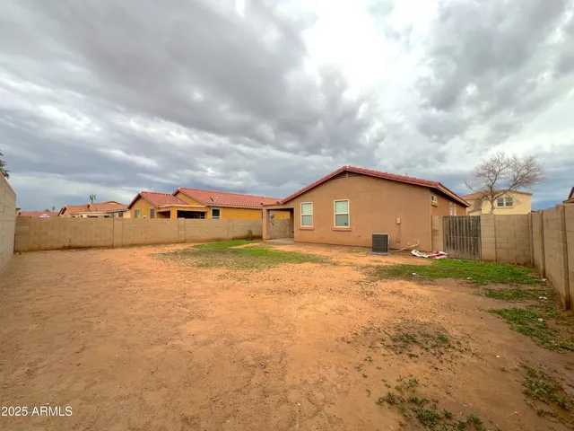 a view of a big house with wooden fence