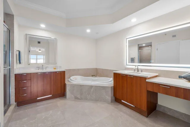 a bathroom with a sink double vanity mirror and a bathtub