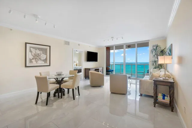 a dining room with furniture and a floor to ceiling window