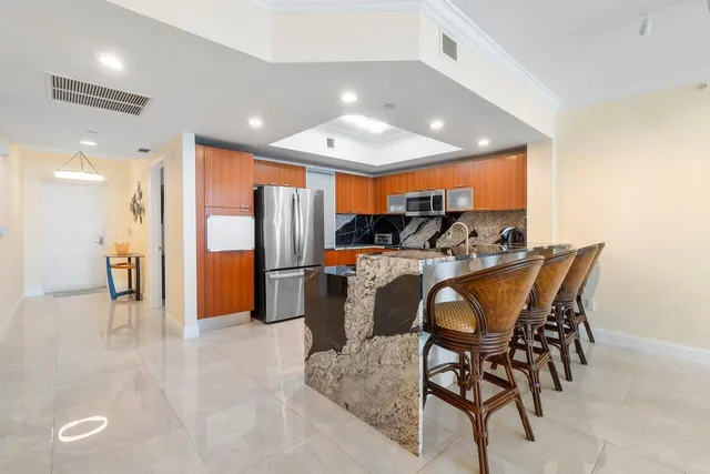 a kitchen with stainless steel appliances granite countertop a refrigerator and a stove