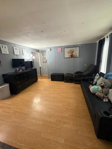 a large bedroom with a bed and a flat tv screen on dresser