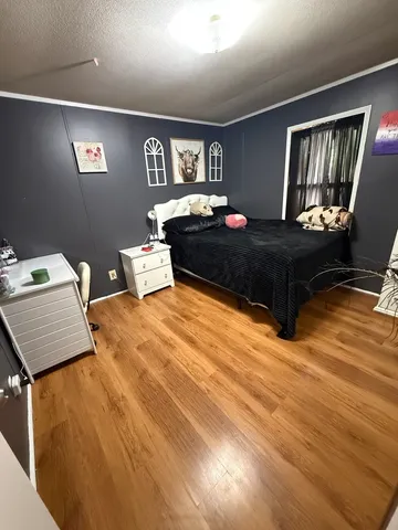 a bedroom with a bed and wooden floor