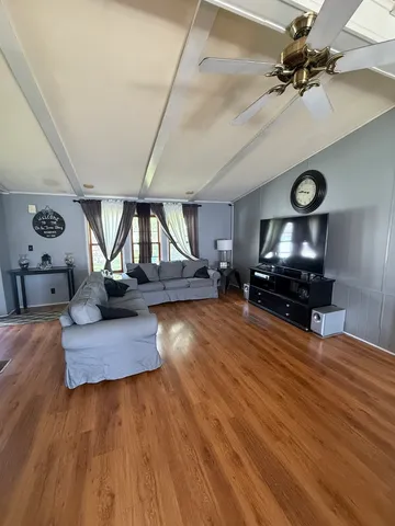 a living room with furniture and a wooden floor