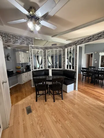 a dining room with wooden floor a glass table and chairs