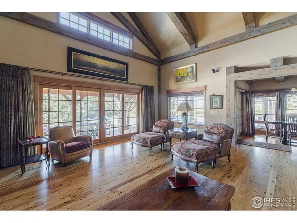 a living room with furniture floor to ceiling window wooden floor and windows