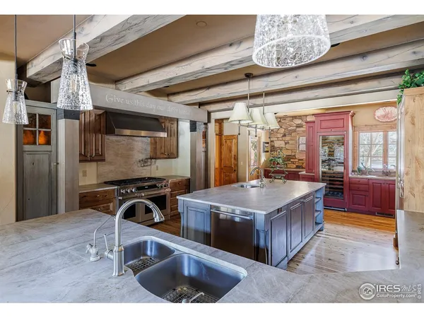 a kitchen with a stove a refrigerator and a sink with wooden floor