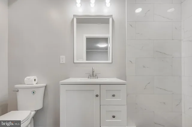 a bathroom with a toilet sink and mirror