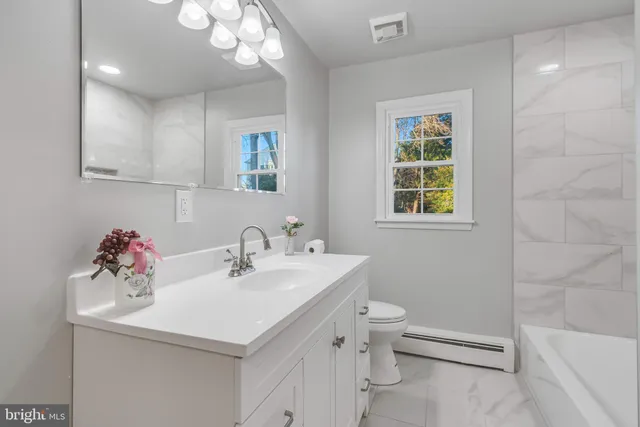 a bathroom with a sink toilet and a mirror