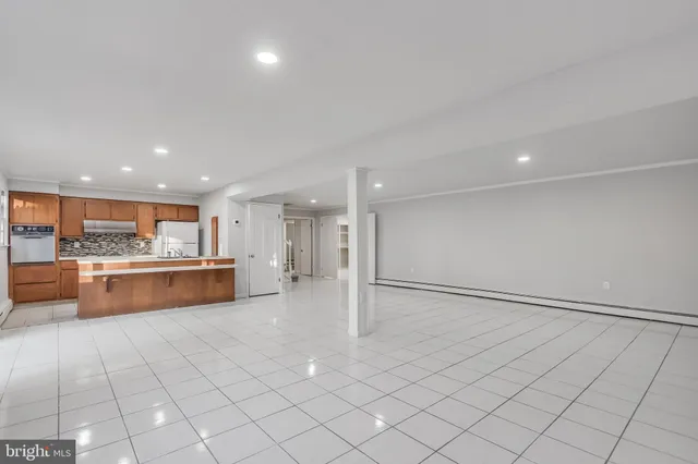 a large white kitchen with a sink and cabinets