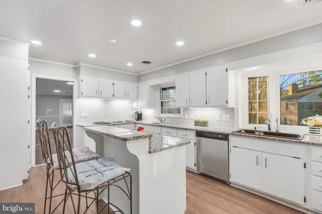 a kitchen with a sink stove cabinets and chairs