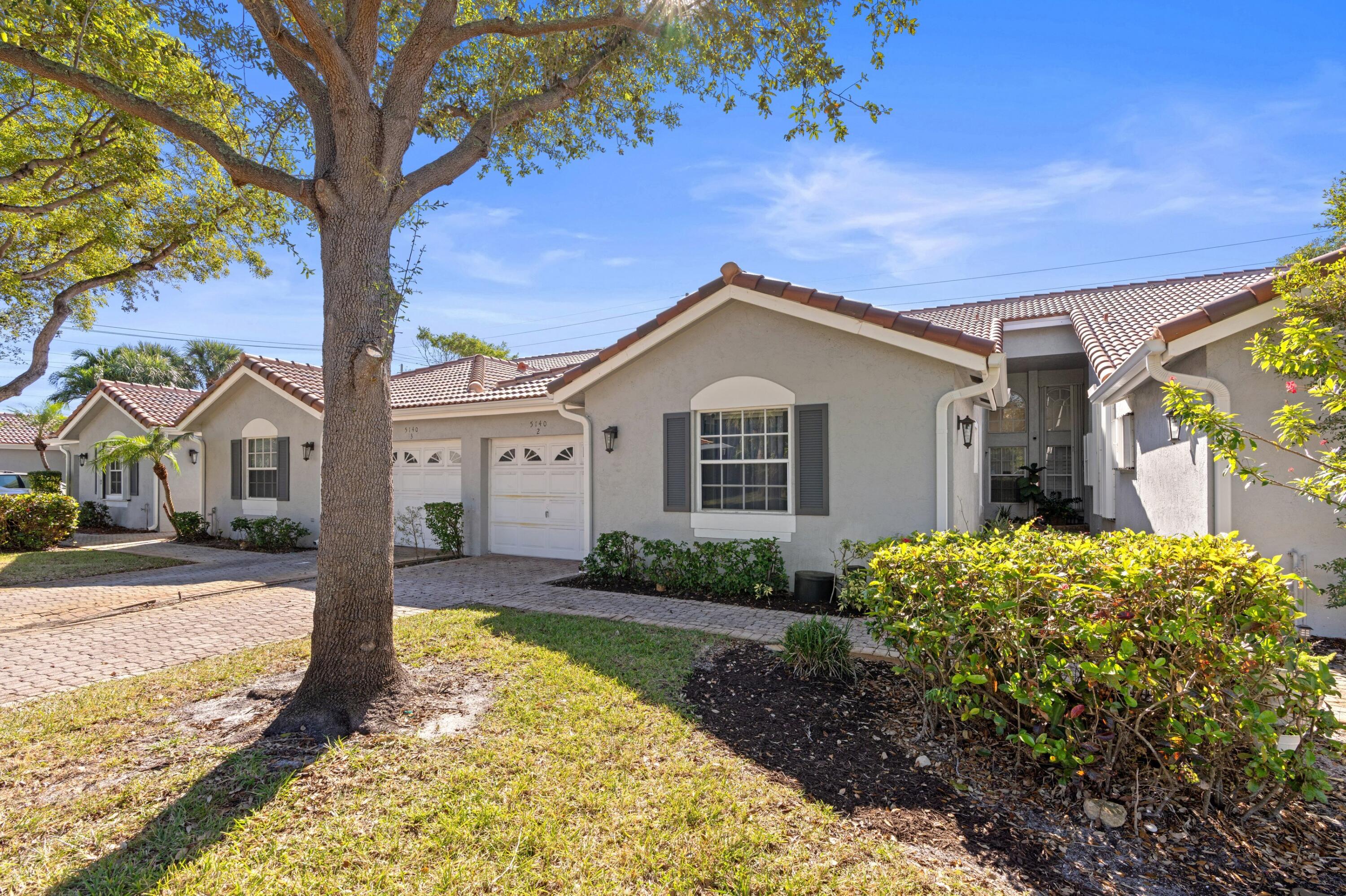 5140 Sabal Gardens Lane, Unit 2 Boca Raton, FL 33487 - Photo 18 of 34 a front view of a house with a yard