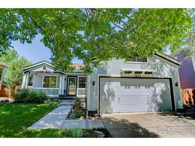 a view of a house with a small yard and potted plants