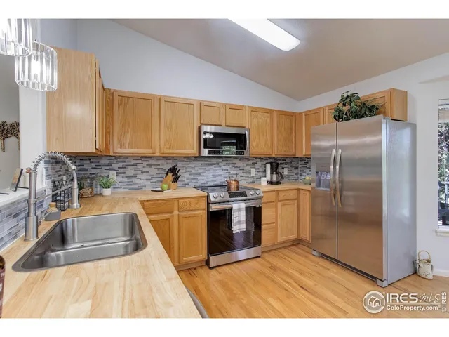 a kitchen with granite countertop a refrigerator and a sink