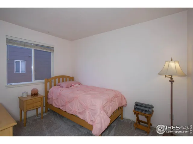 a bedroom with a bed a lamp and a couch