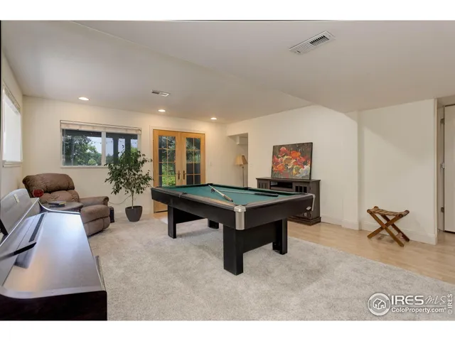 a living room with furniture pool table and a rug