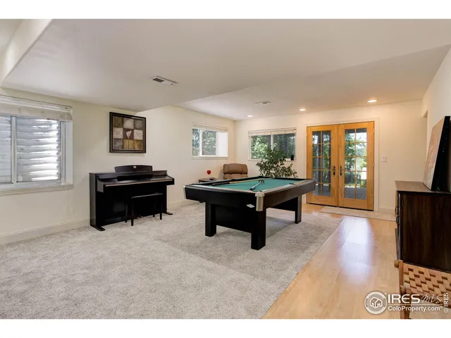 a living room with furniture and a pool table