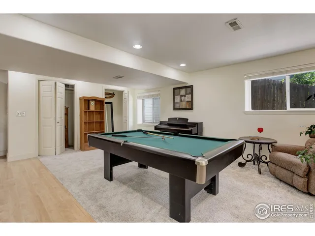a room with furniture pool table and windows
