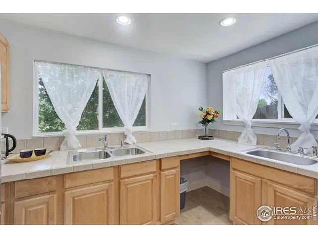 a kitchen with a sink window and cabinets