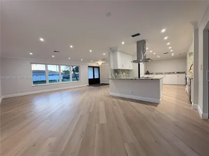 a view of kitchen with kitchen island wooden floor and center island