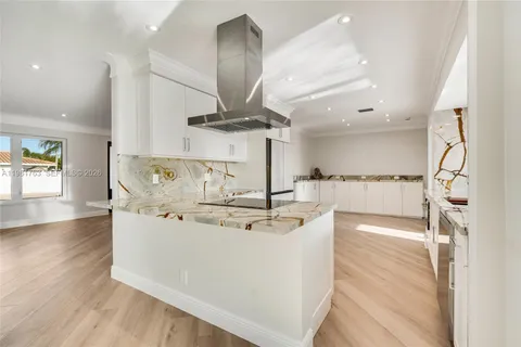 a view of kitchen with stainless steel appliances kitchen island a stove and a wooden floors