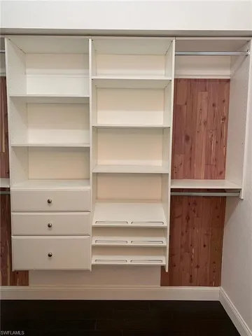 a view of walk in closet with empty racks