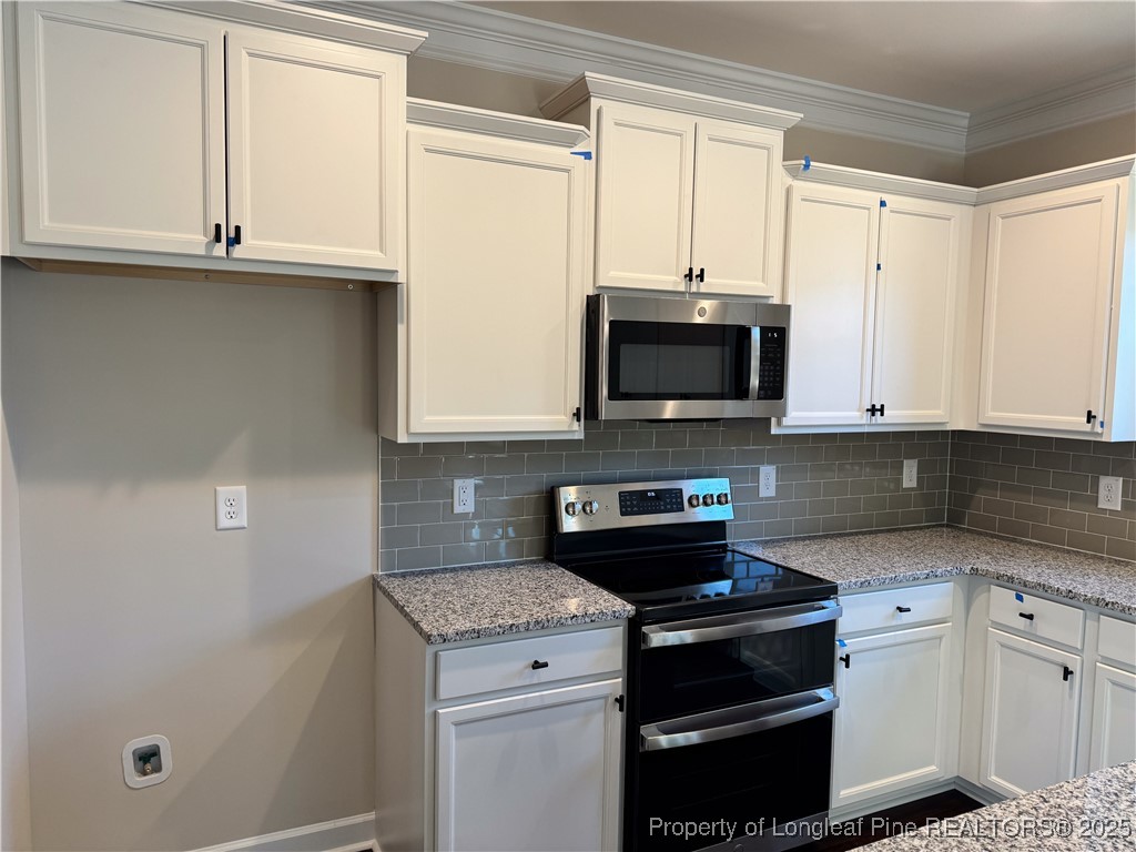 2 Collier Road Wade, NC 28395 - Photo 9 of 18 a kitchen with granite countertop a stove and a microwave
