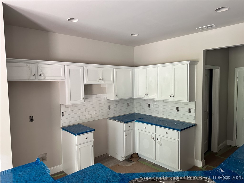 2 Collier Road Wade, NC 28395 - Photo 10 of 18 a kitchen with a sink dishwasher and white cabinets with wooden floor