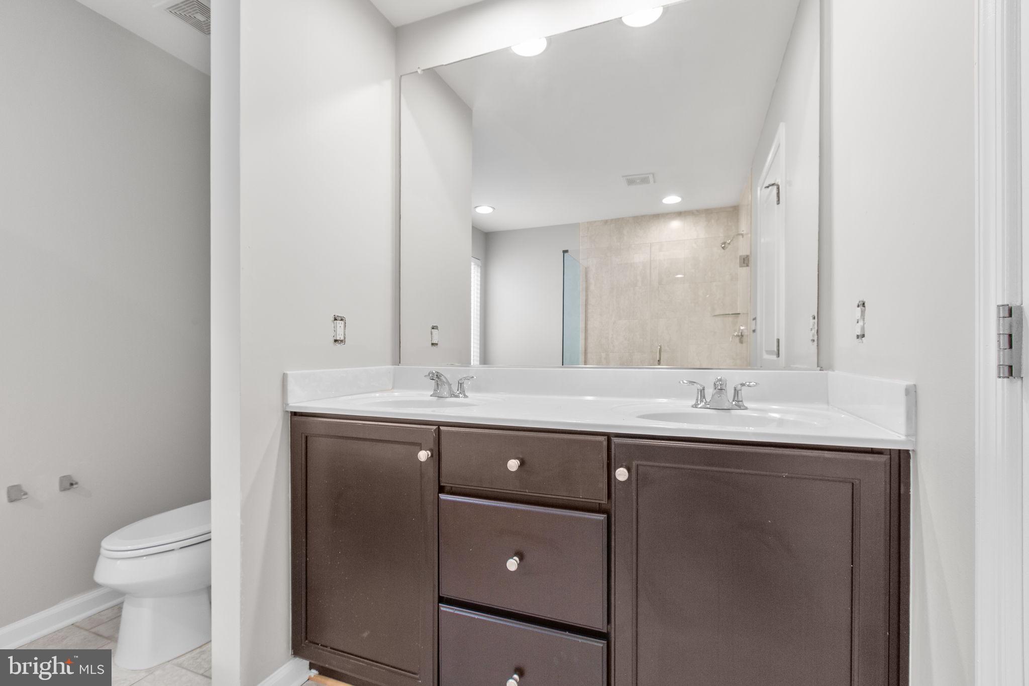 930 Forsythia Lane Stafford, VA 22554 - Photo 37 of 81 a bathroom with a granite countertop sink a toilet and a mirror
